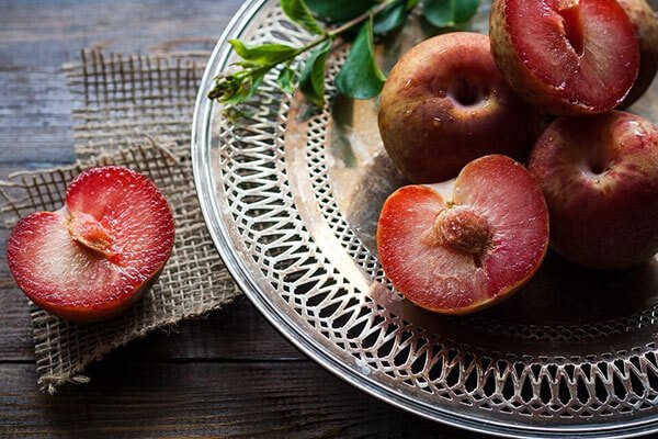 plate of plums cut in half
