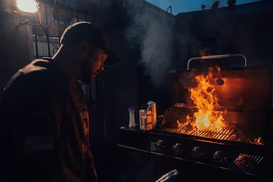 man using a flaming bbq for outdoor cooking