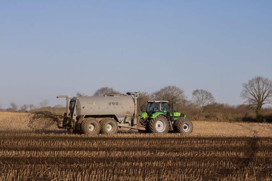 farmer spreading synthetic fertilizer