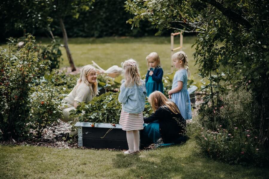 adult explaining garden activities for kids to a group of children outdoors