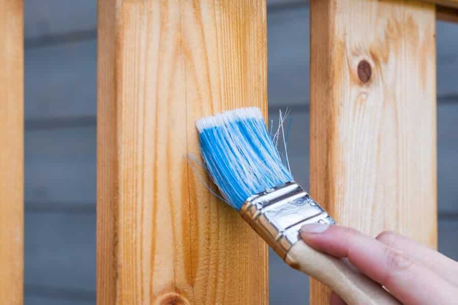 person applying oil to wood which is an effective way to preserve wood